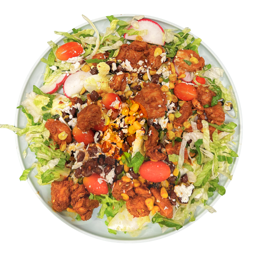 Colorful BBQ Chicken Ranch salad with chicken, vegetables, and dressing on a white plate