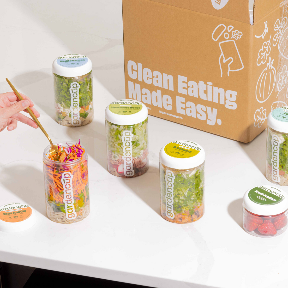Gardencups on a table with a cardboard box labeled 'Clean Eating Made Easy'.