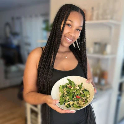 A happy woman holding a bowl of GardenCup™ salad, showing how easy healthy eating can be with fresh salad delivery right to your door.