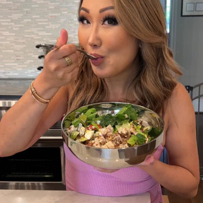 A woman eating a fresh GardenCup™ salad, enjoying a healthy, convenient meal made for busy lifestyles.
