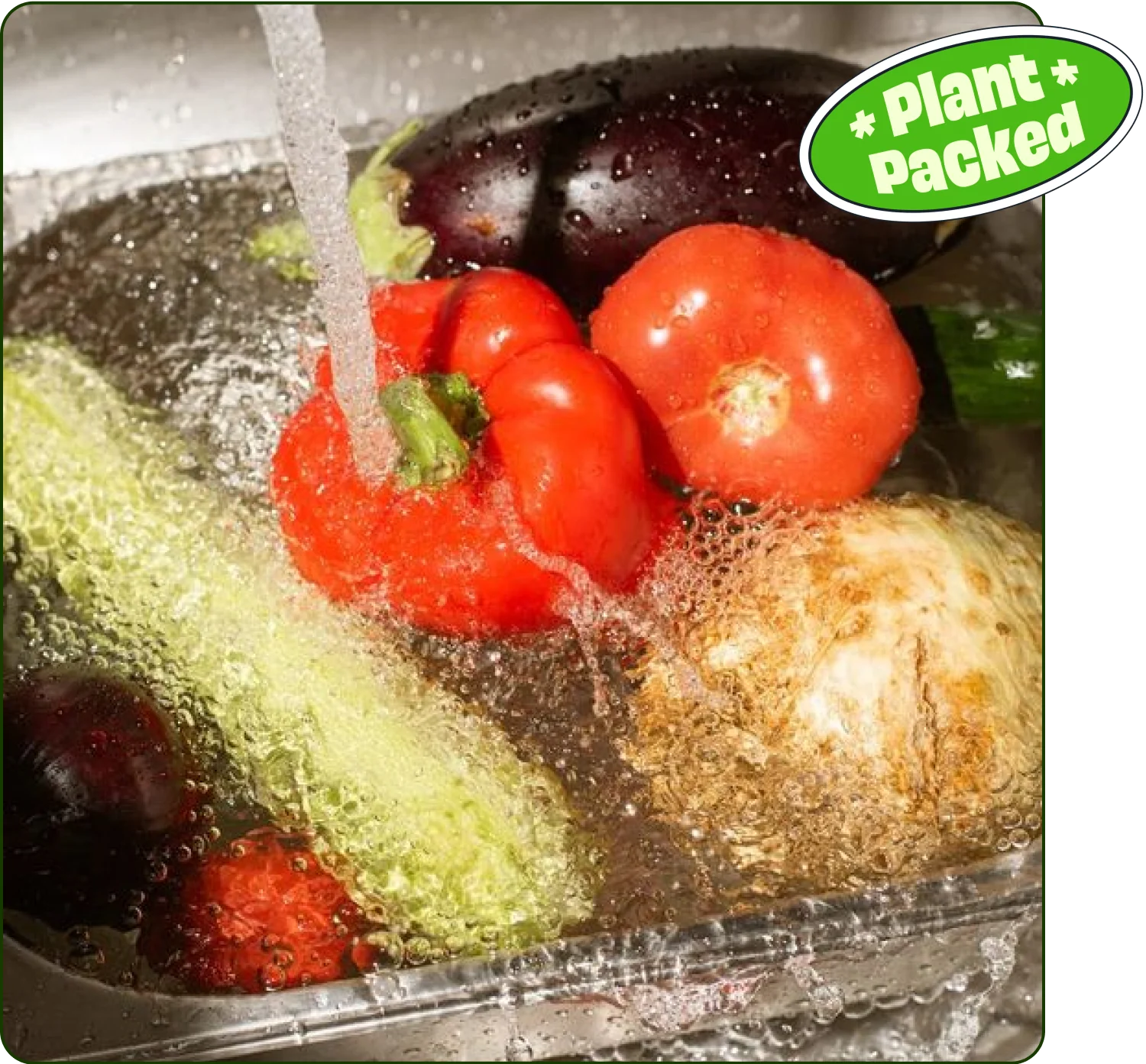 A close-up of fresh vegetables including peppers, tomatoes, eggplant, and cucumber being washed in water. Represents GardenCup’s plant-packed, fresh, and healthy ingredients used in every salad delivery.